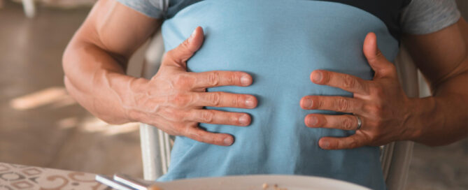 A man with digestive issues holding his gut