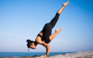 A woman doing yoga on the beach